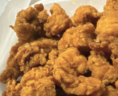 Crispy golden popcorn chicken on paper lining