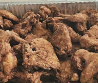 A pan of freshly fried chicken pieces
