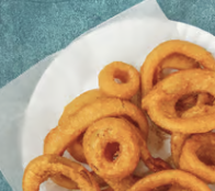 Golden fried onion rings on a paper liner