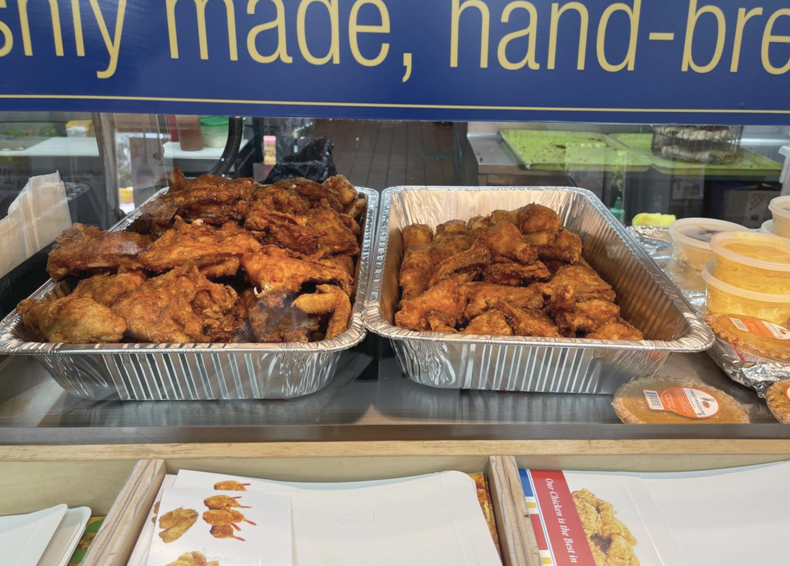 Two full trays of golden fried chicken ready for catering